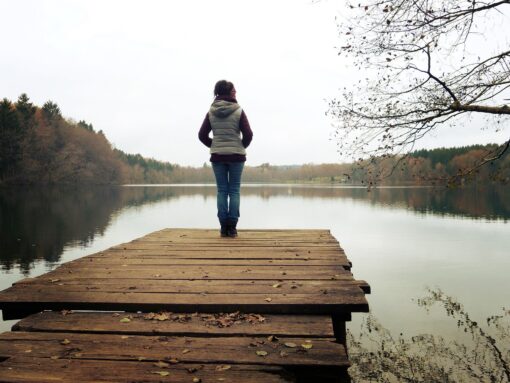 Frau auf Steg am See