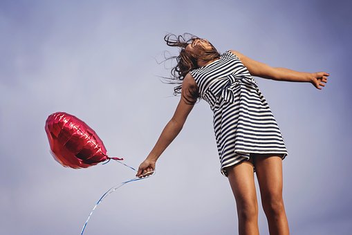 Frau die springt mit Ballon